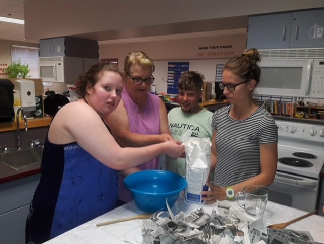 teachers and students measuring flour